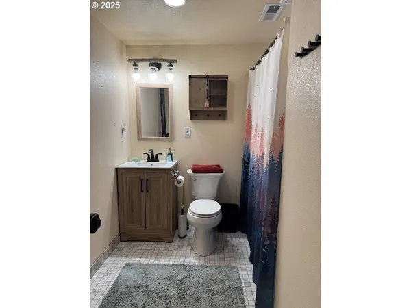 a bathroom with a sink a toilet and mirror