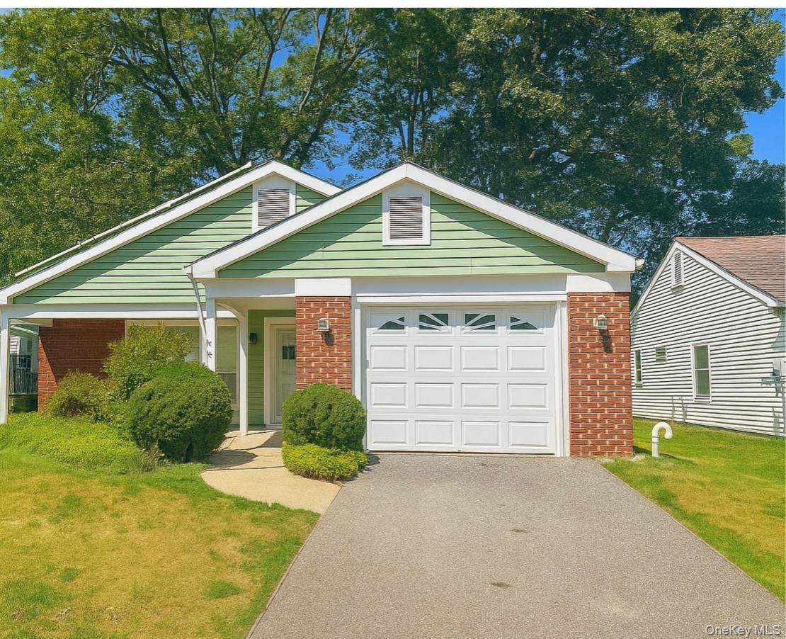 503 Lancaster Court, Unit 503 Ridge, NY 11961 - Photo 1 of 1 View of front of property with brick siding, driveway, a front yard, and a garage
