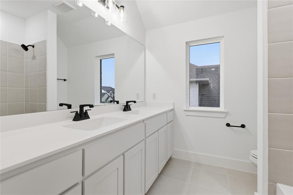 1653 Cedar Elm Way Burleson, TX 76028 - Photo 19 of 26 a bathroom with a double vanity sink a mirror and shower