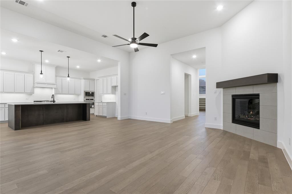 1653 Cedar Elm Way Burleson, TX 76028 - Photo 4 of 26 a view of an empty room with kitchen view and a fireplace