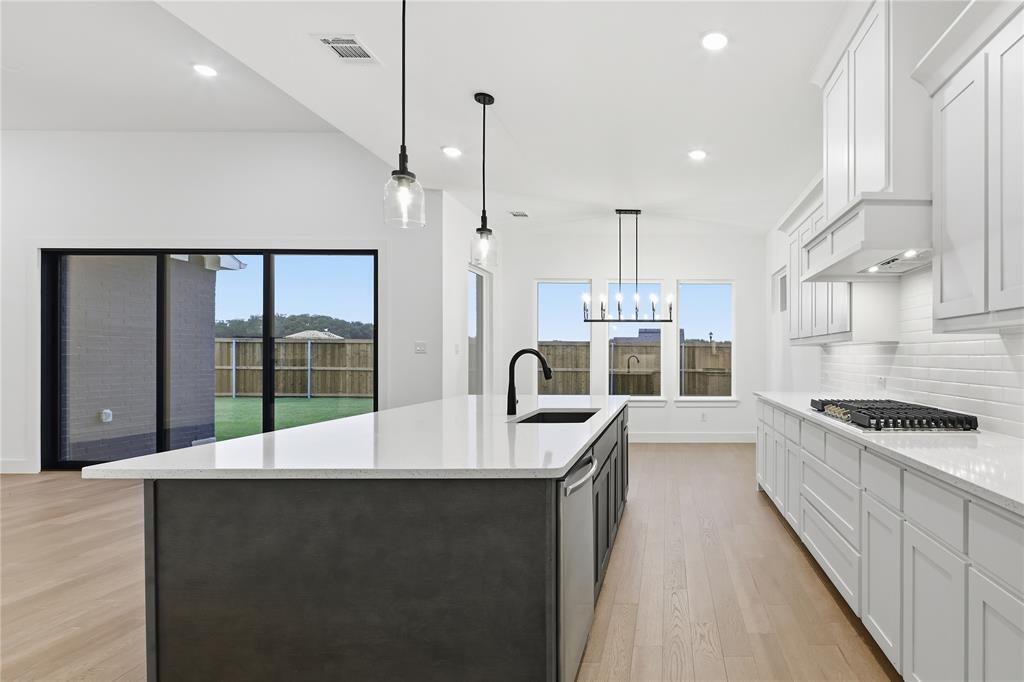 1653 Cedar Elm Way Burleson, TX 76028 - Photo 7 of 26 a large kitchen with kitchen island a large counter top space a sink and stainless steel appliances