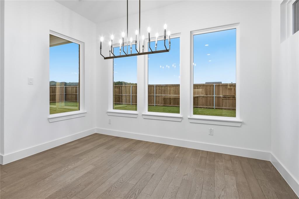 1653 Cedar Elm Way Burleson, TX 76028 - Photo 10 of 26 a view of an empty room with wooden floor and a window