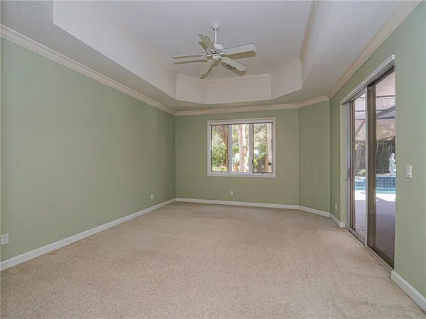 an empty room with fan and windows