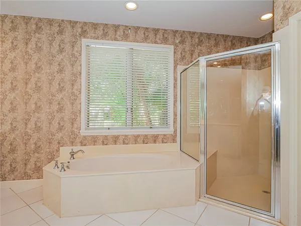 a white bath tub sitting next to a shower