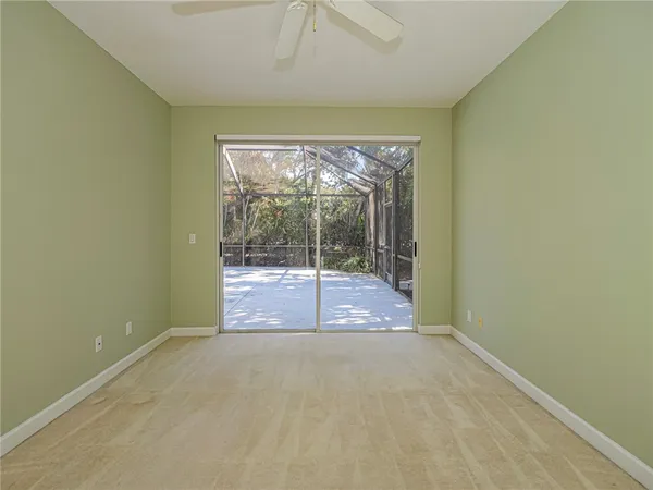 a view of an empty room with wooden floor and a fireplace