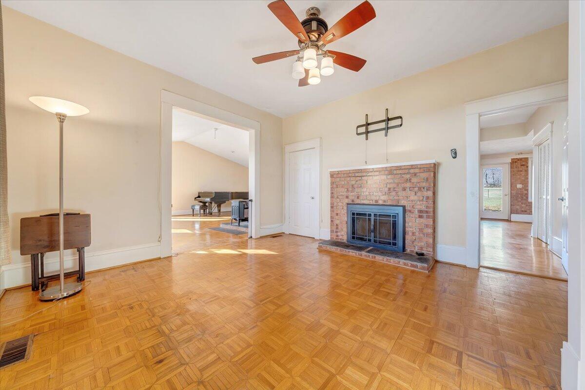 181 Chestnut Grove Road Callaway, VA 24067 - Photo 10 of 51 a view of a livingroom with a fireplace a chandelier a wooden table and chairs