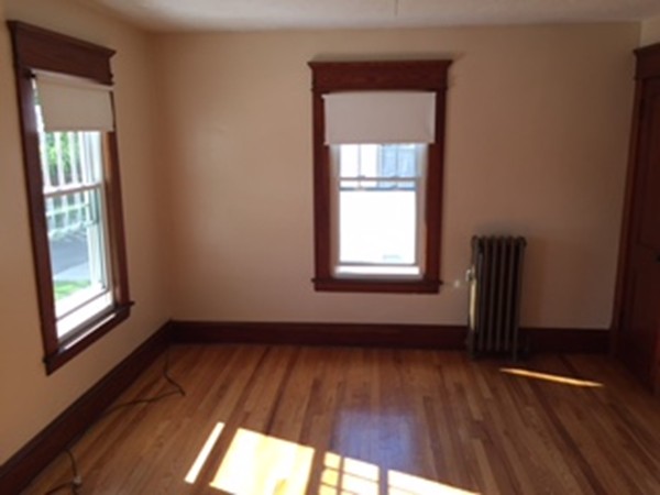 15-17 Windemere Street Springfield, MA 01104 - Photo 6 of 9 an empty room with wooden floor and windows