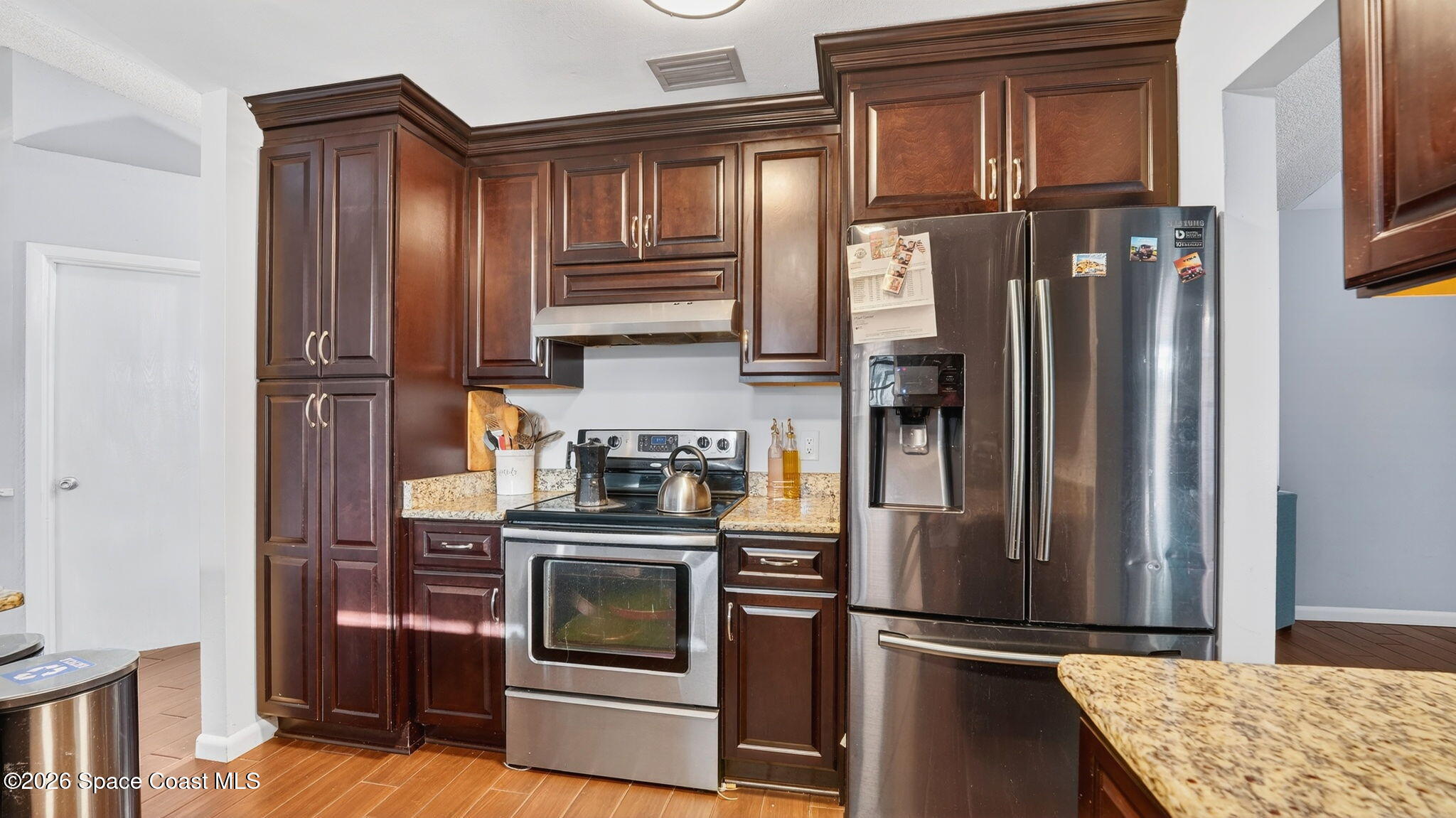 6398 Cable Avenue Cocoa, FL 32927 - Photo 13 of 30 a kitchen with stainless steel appliances granite countertop a refrigerator and a stove