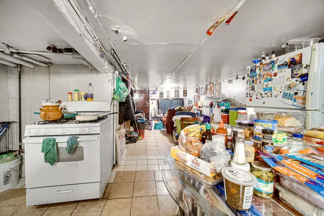 a utility room with lots of clutter and refrigerator