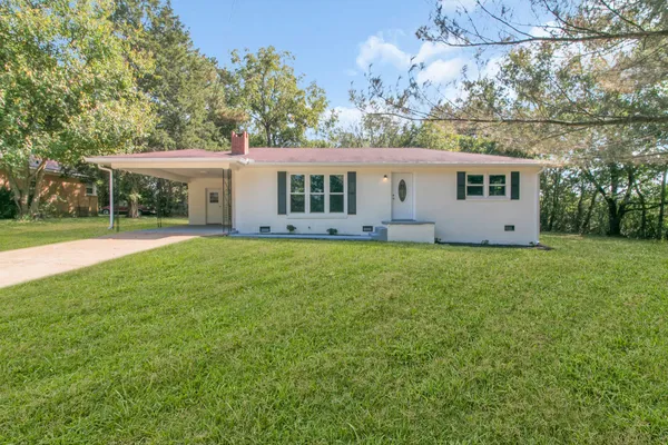 a view of a house with yard and sitting area