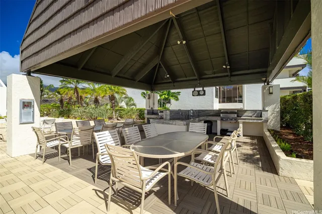 a view of a patio with table and chairs under an umbrella