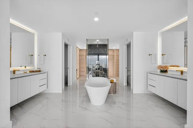 a large bathroom with a tub sink and mirror