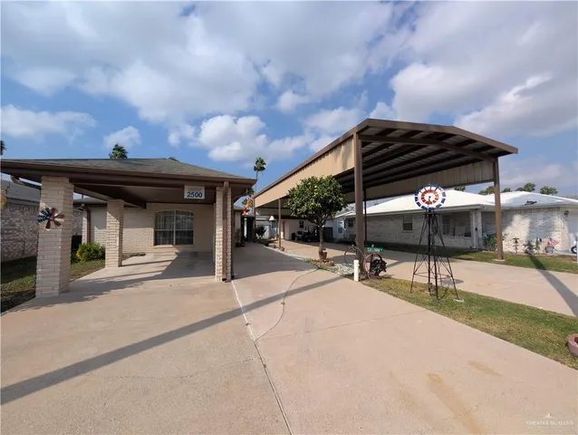 a view of the patio with table and chairs under an umbrella