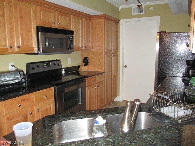 13581 Eagle Ridge Drive, Unit 1414 Fort Myers, FL 33912 - Photo 1 of 15 a kitchen with stainless steel appliances granite countertop a stove a sink and a microwave