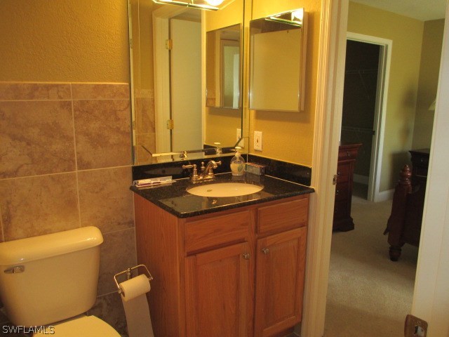 13581 Eagle Ridge Drive, Unit 1414 Fort Myers, FL 33912 - Photo 12 of 15 a bathroom with a granite countertop sink toilet and shower