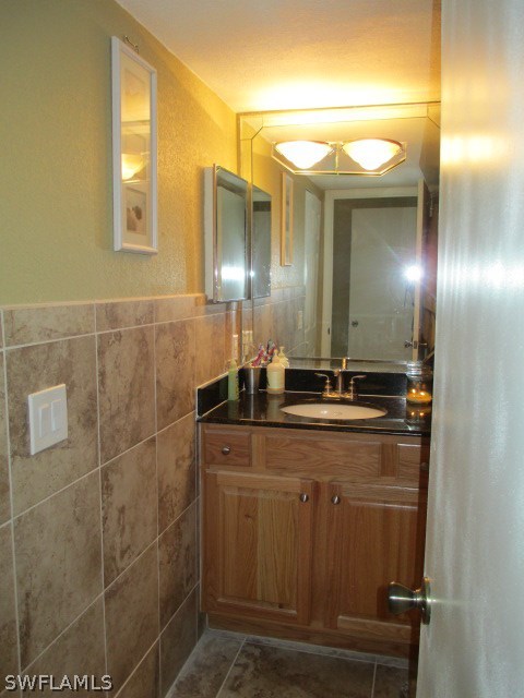 13581 Eagle Ridge Drive, Unit 1414 Fort Myers, FL 33912 - Photo 5 of 15 a bathroom with a sink a large mirror and a shower