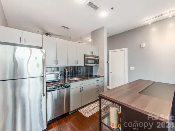 a living room with furniture kitchen view and a chandelier