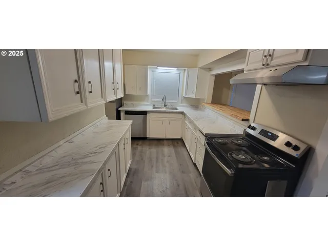 a kitchen with stainless steel appliances granite countertop a stove a sink and a refrigerator