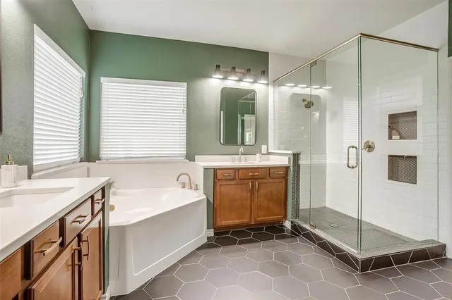 a bathroom with a tub a sink and a mirror