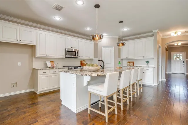 a kitchen with white cabinets and stainless steel appliances