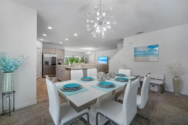 a kitchen with stainless steel appliances granite countertop a table chairs sink refrigerator and cabinets