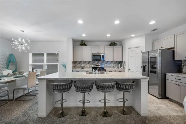 a kitchen with kitchen island granite countertop a counter top space appliances and cabinets