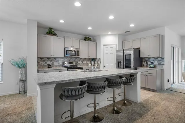a kitchen with stainless steel appliances granite countertop a sink stove and refrigerator