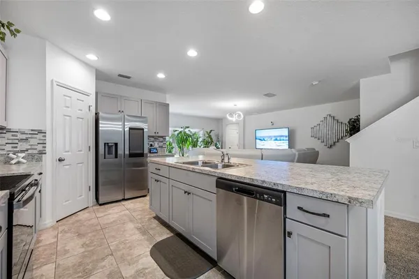 a kitchen with stainless steel appliances granite countertop a refrigerator sink and stove