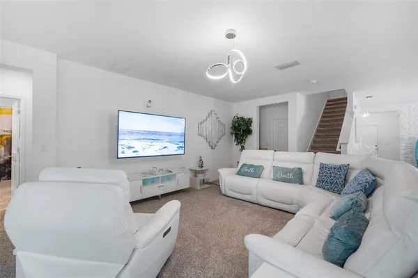 a living room with furniture and a view of kitchen