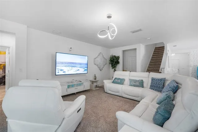 a living room with furniture and a view of kitchen
