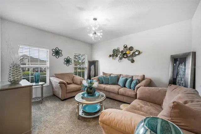 a living room with furniture and a chandelier