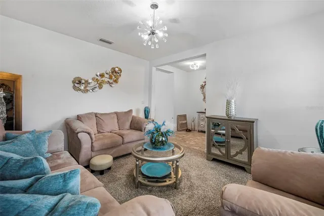 a living room with furniture a dining table and kitchen view