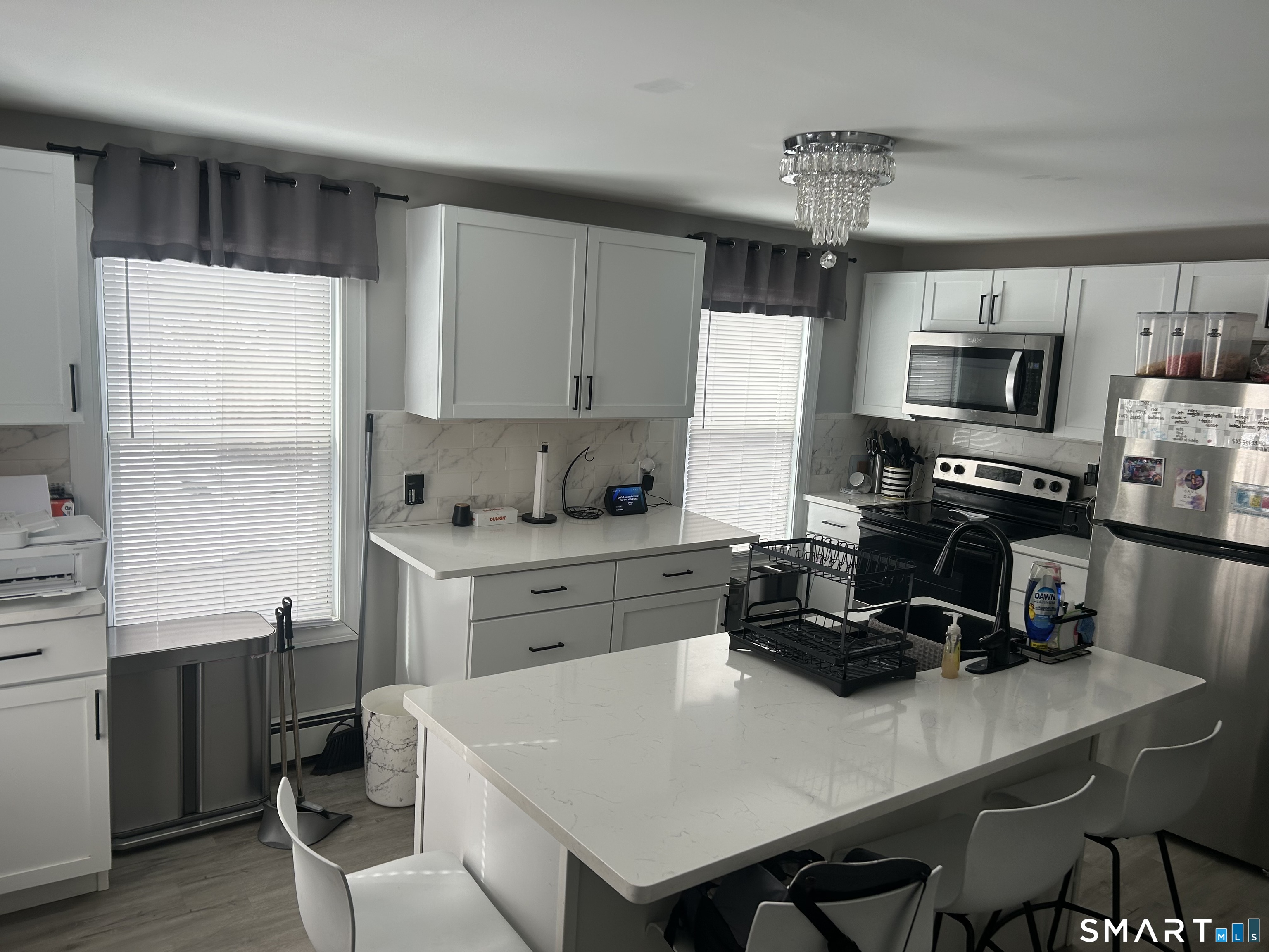 146 Liberty Street Middletown, CT 06457 - Photo 7 of 11 a kitchen with a stove a sink a microwave a dining table and chairs