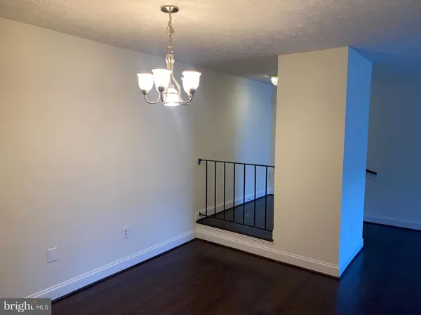 a view of a room with wooden floor and chandelier