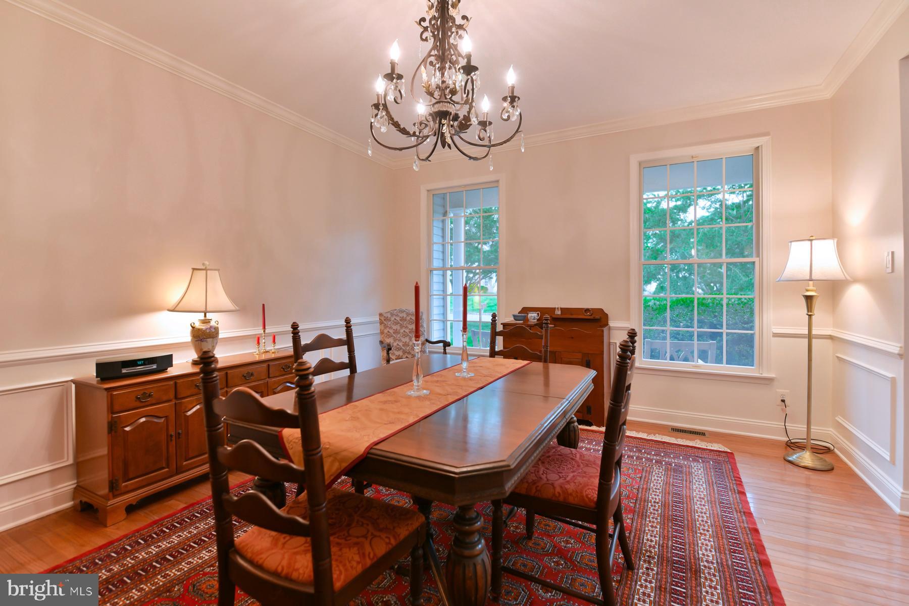 31 Millwood Drive Mickleton, NJ 08056 - Photo 15 of 62 a dining room with wooden floor a chandelier a wooden table and chairs