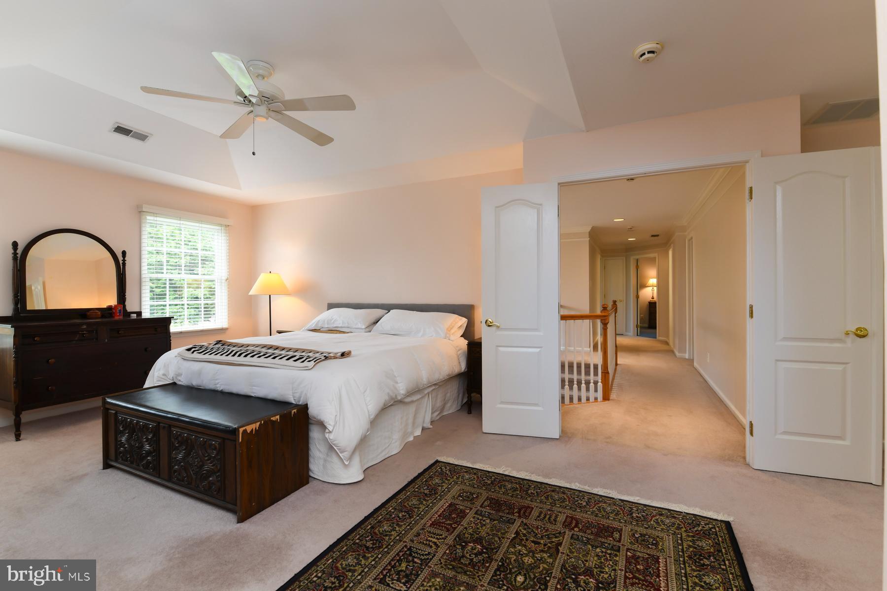 31 Millwood Drive Mickleton, NJ 08056 - Photo 37 of 62 a spacious bedroom with a bed a mirror and a chandelier