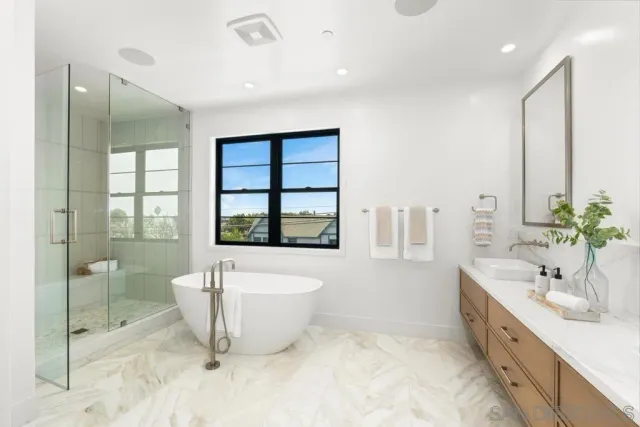 a spacious bathroom with a double vanity sink a mirror and a bathtub