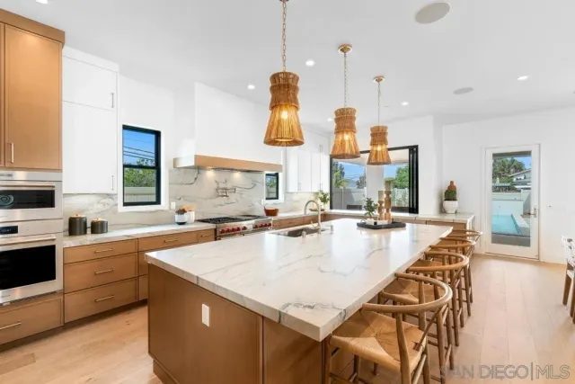 a large kitchen with granite countertop a sink counter top space and stainless steel appliances