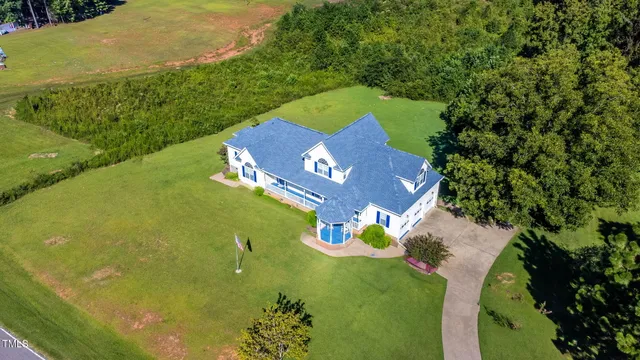 an aerial view of a house with a yard and lake view