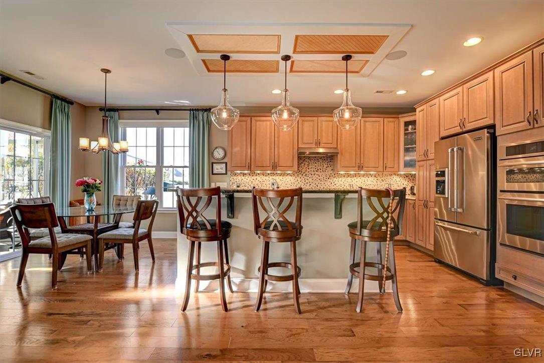 1039 Declaration Drive Bethlehem, PA 18017 - Photo 22 of 50 a kitchen with stainless steel appliances a dining table chairs stove and white cabinets