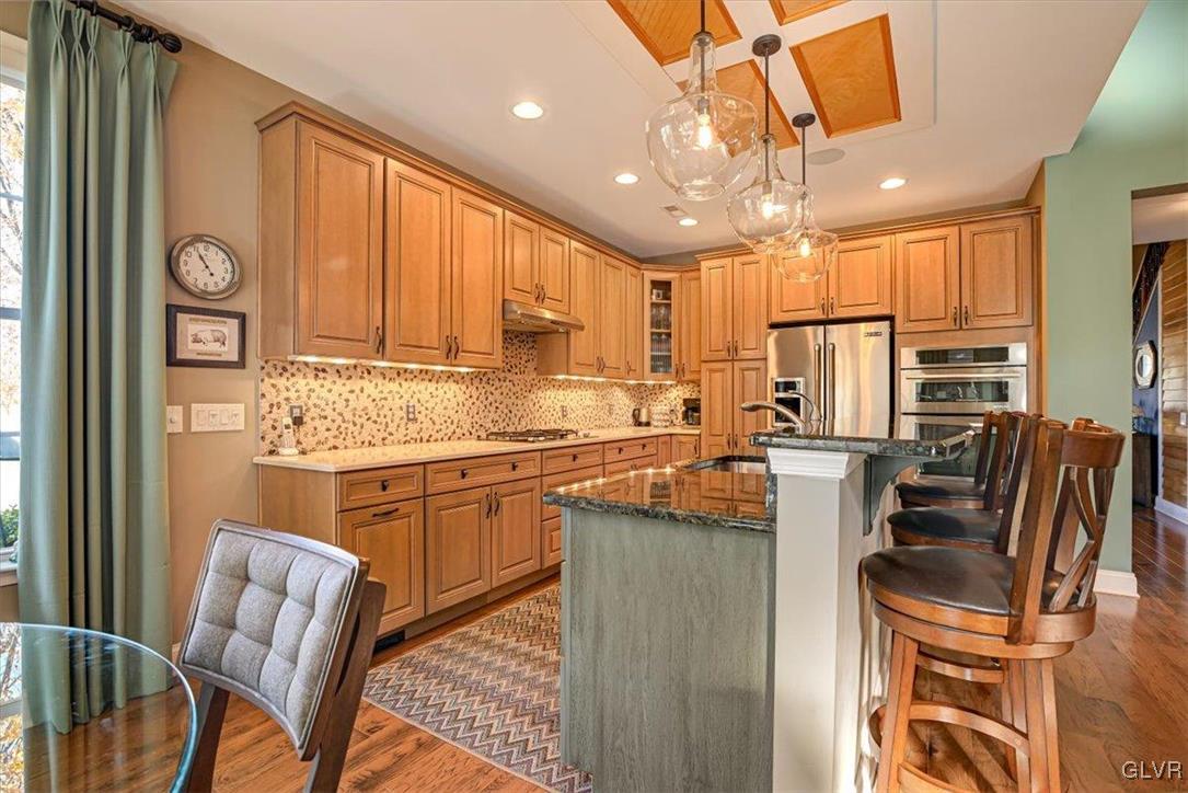 1039 Declaration Drive Bethlehem, PA 18017 - Photo 24 of 50 a kitchen with stainless steel appliances granite countertop a stove top oven a refrigerator a sink and a dining table with granite countertops