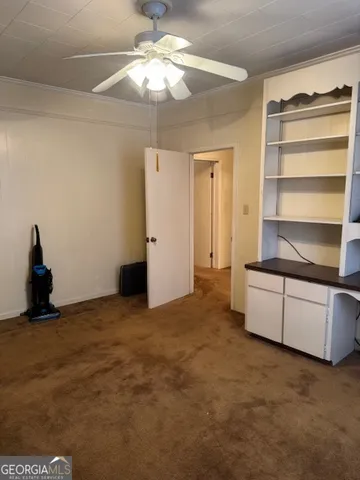 a view of an empty room with a cabinet and a window
