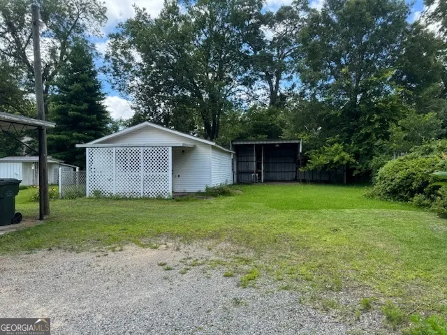a front view of a house with a garden and trees