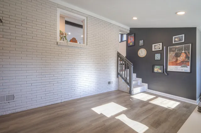 a view of a hallway with wooden floor and entryway