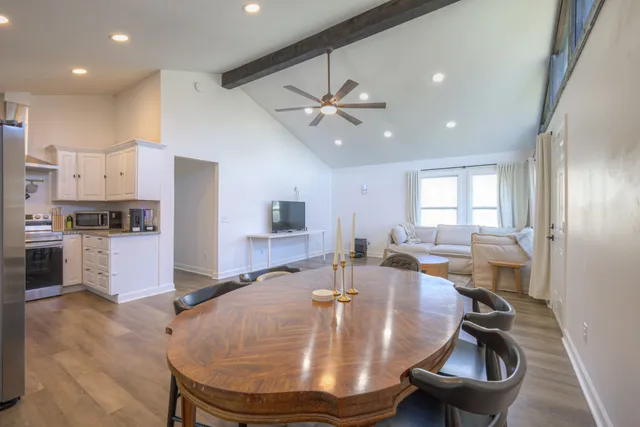 a room with stainless steel appliances wooden floor dining table and chairs