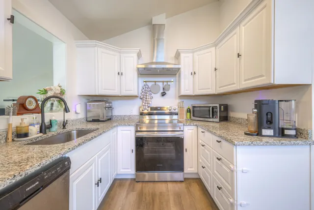a kitchen with granite countertop a stove top oven sink and cabinets