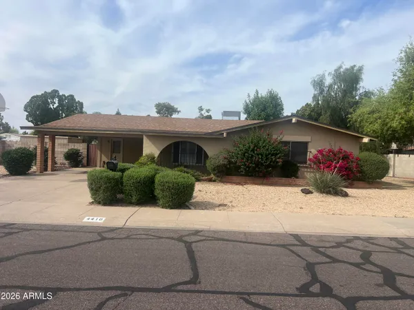 a front view of a house with a yard and potted plants
