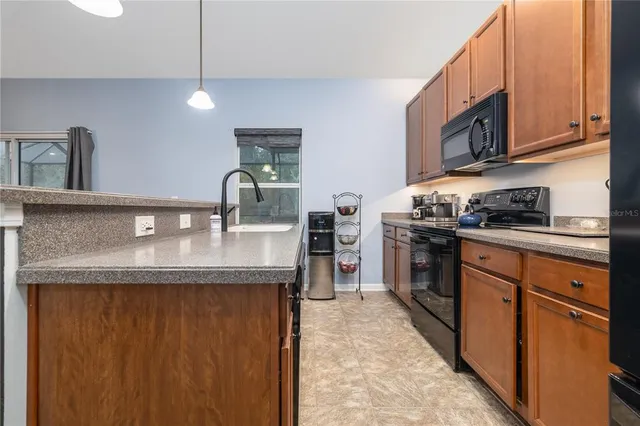 a kitchen with stainless steel appliances granite countertop a sink a stove and a refrigerator
