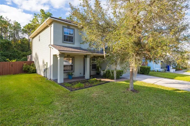 a view of a house with a yard and tree s