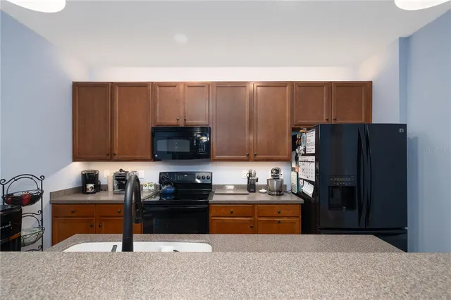 a kitchen with a sink a refrigerator and cabinets
